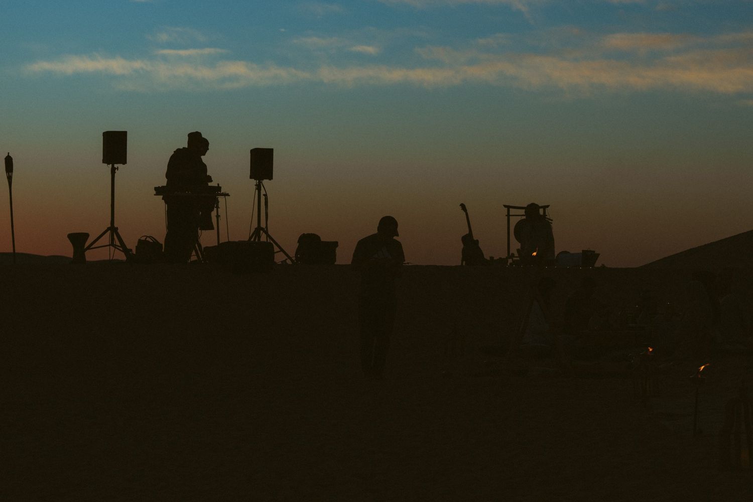 Silhouette of a DJ booth in the desert at dusk