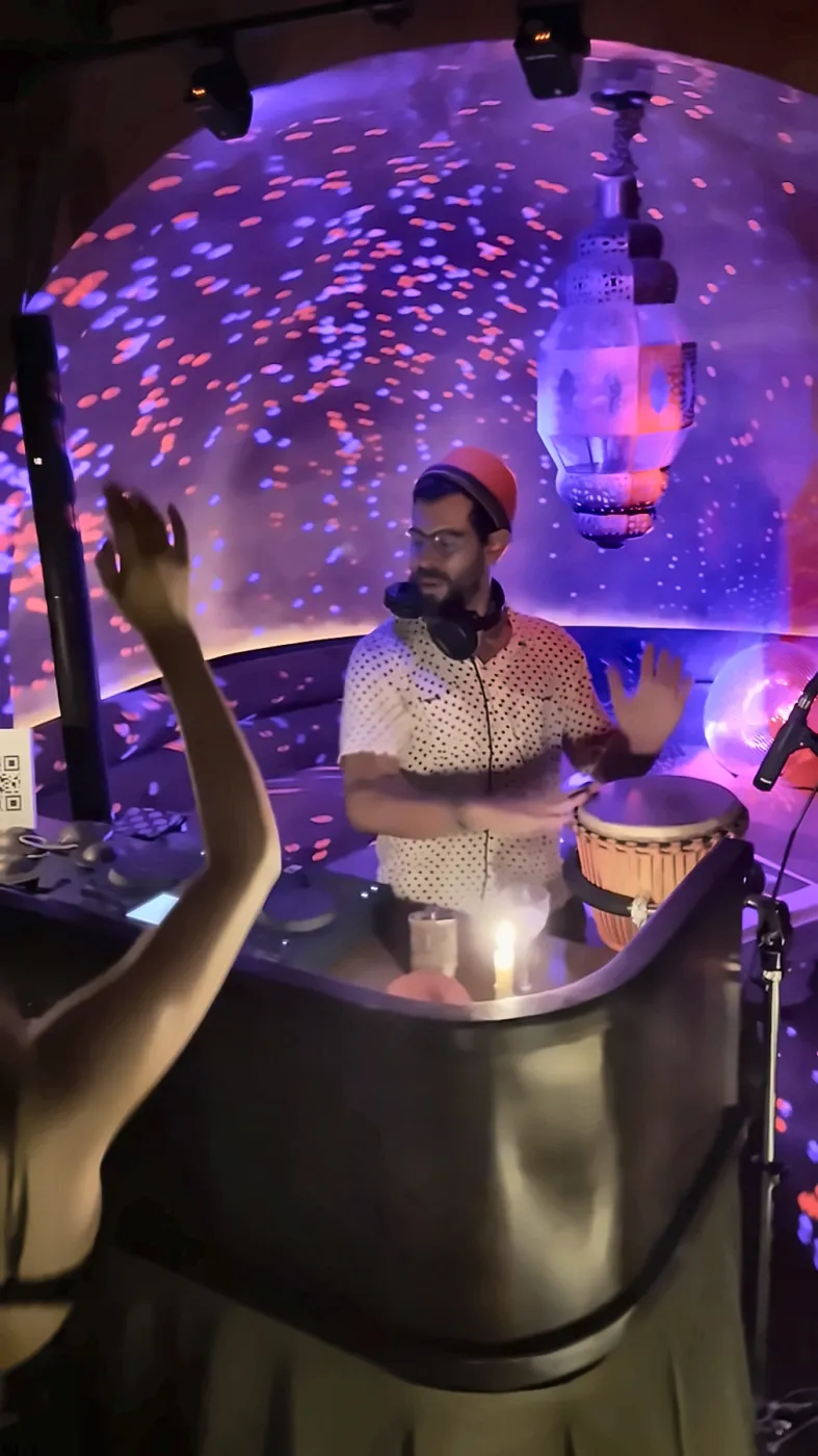 A dancer raises her hand while Taïb plays at Clandestinna