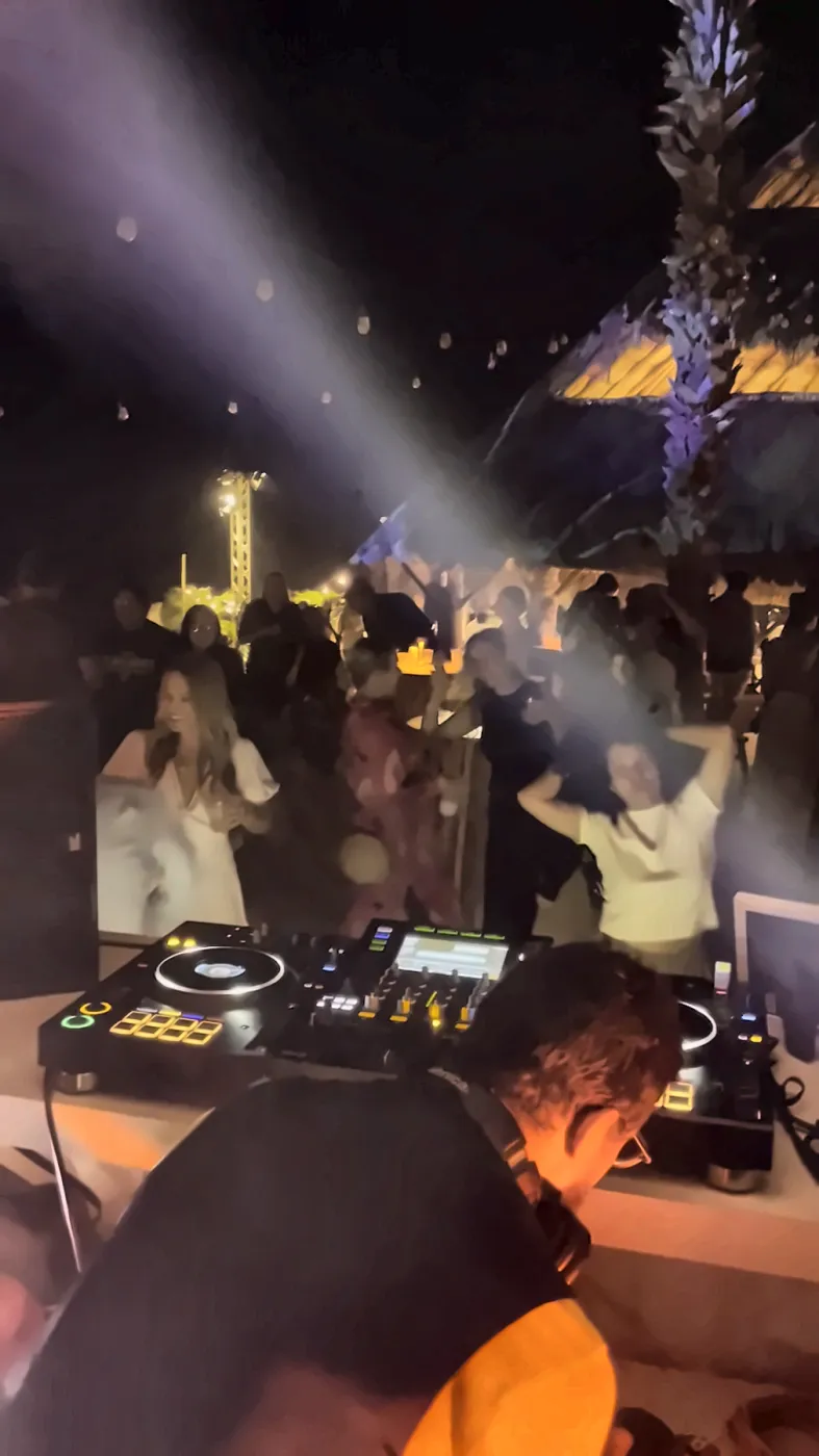 Hands in the air under the lasers at a festival night