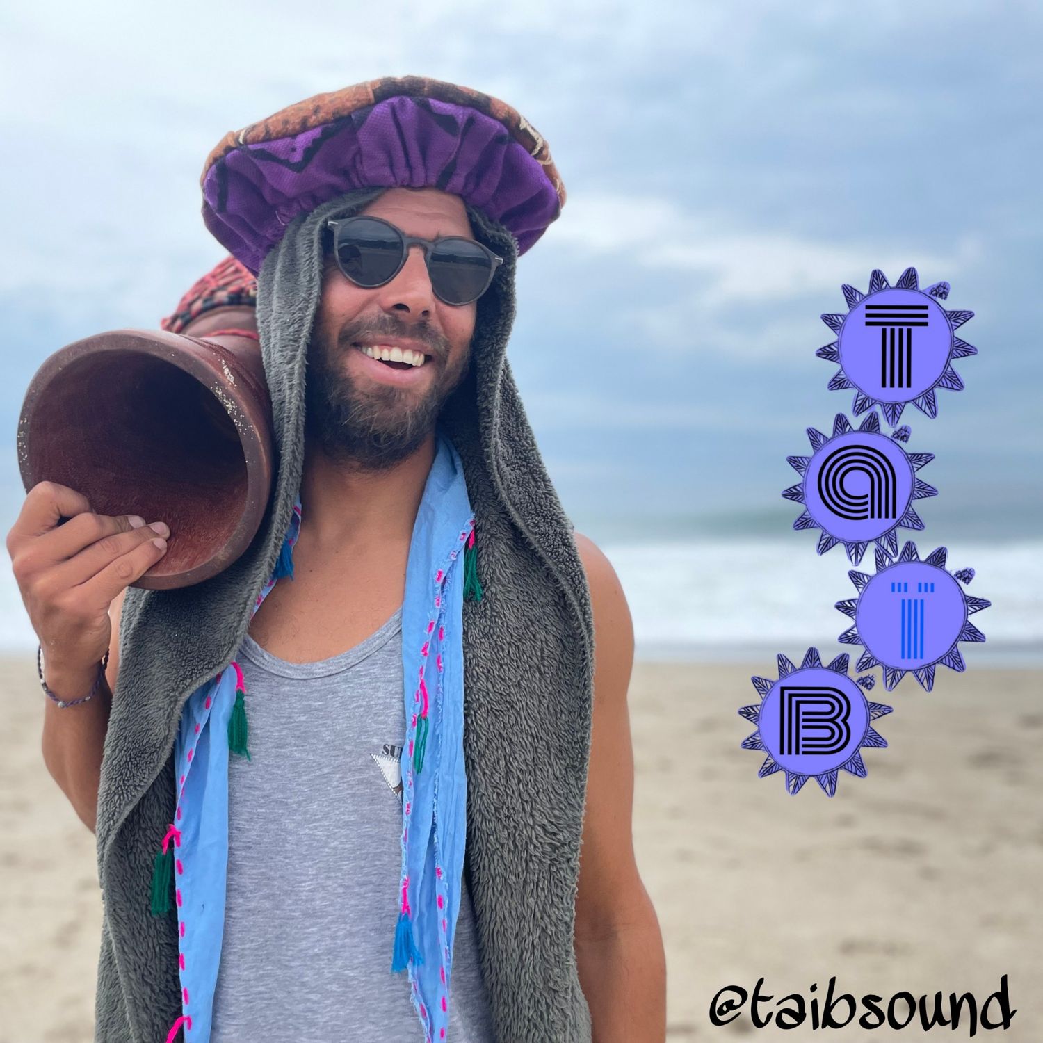 Taïb on the beach with a drum on his shoulder